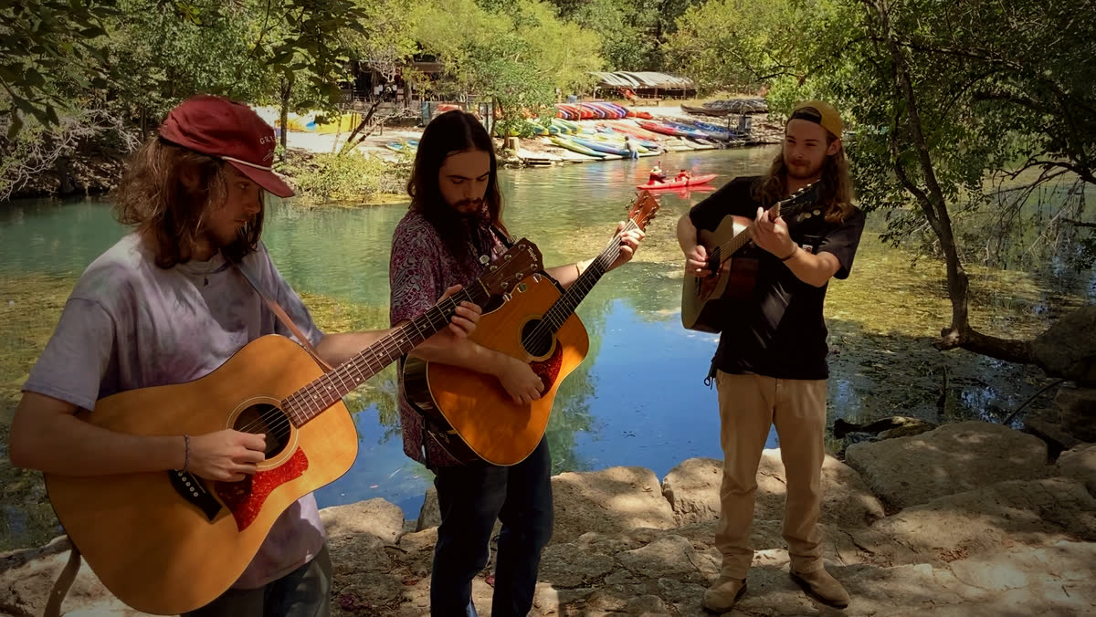 The Wingos playing by the San Marcos river